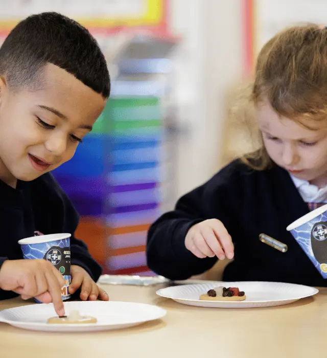 girl and boy decorating biscuit as part of the independent primary curriculum
