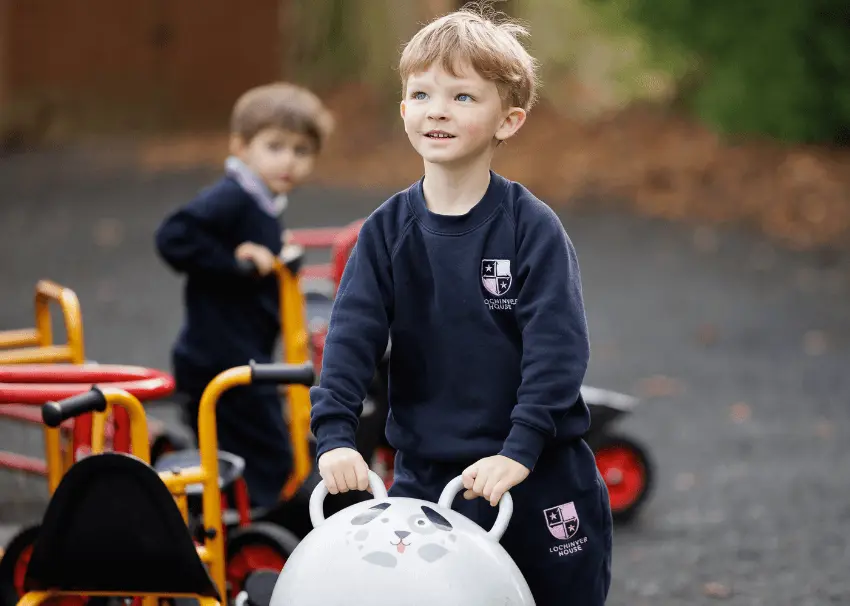 Boys in pre prep play area on spacehoppers