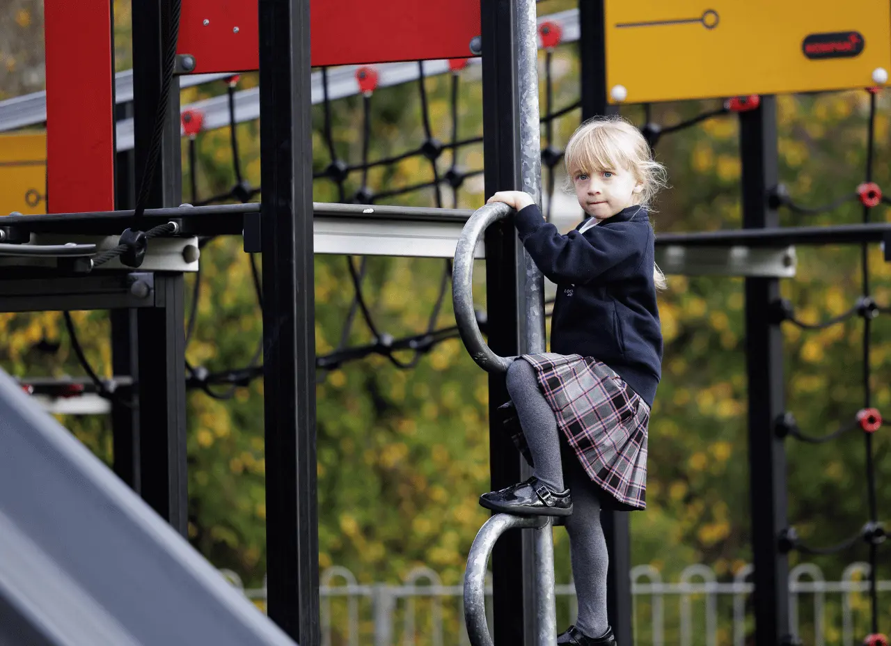 girl on climbing frame at school