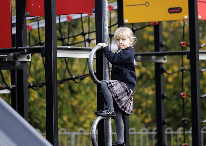 girl on climbing frame in school adventure playground