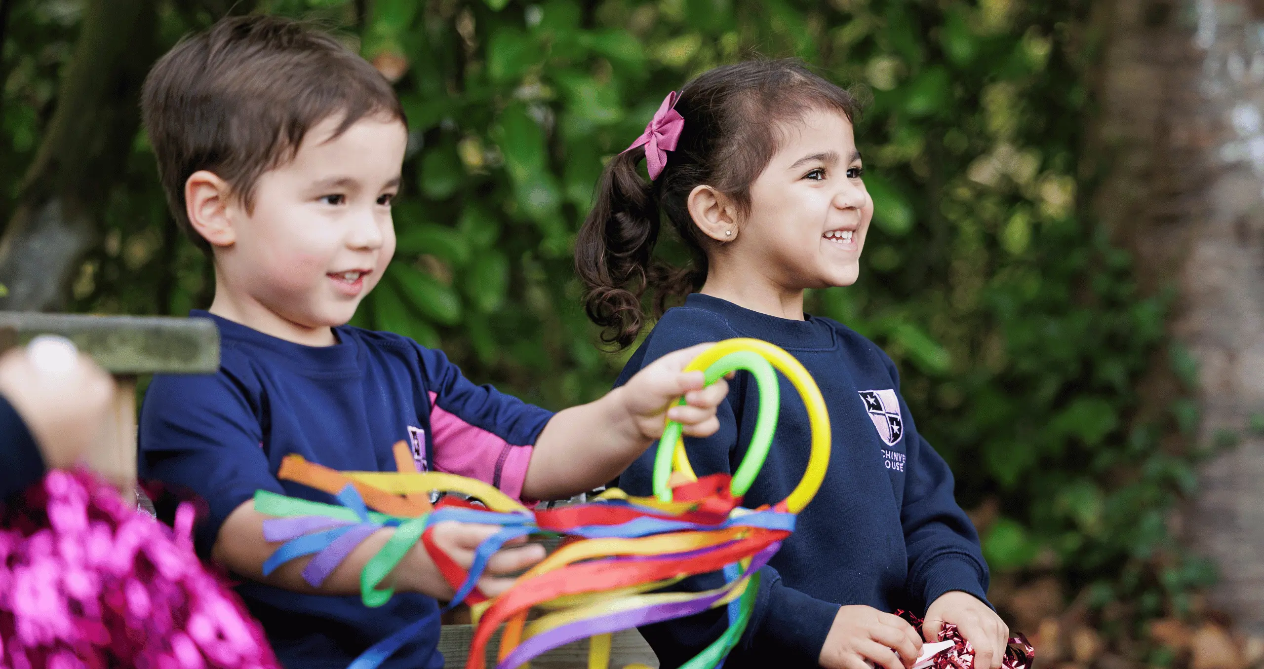 children playing with hoop ribbons and pompoms as part of independent primary curriculum